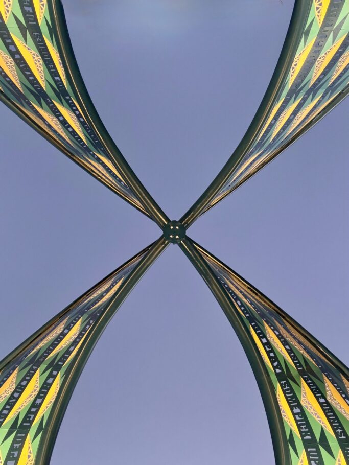 “Energetic” sculpture by artist Blessing Hancock in Fort Worth’s Sycamore Park — a colorful, figure-eight-shaped metal artwork with curving forms and community-inspired text bands, fabricated and installed by Gizmo Art Production.